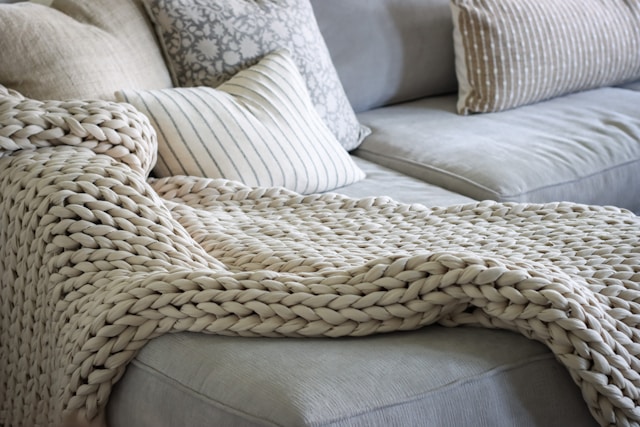 A couch with a blanket on top of it